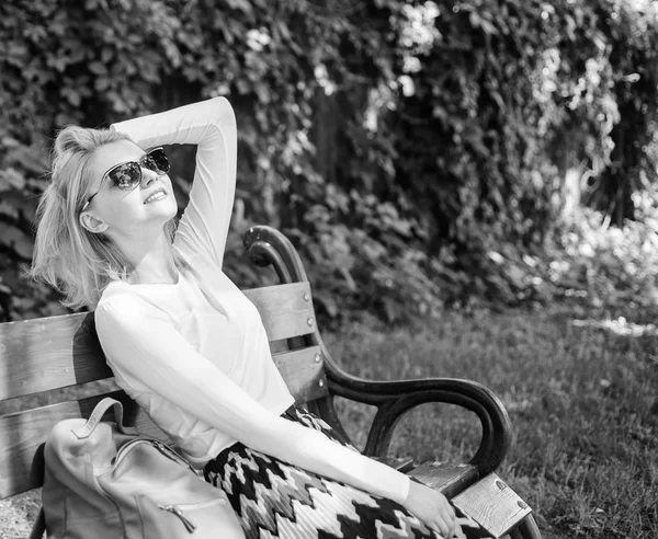 La dame a besoin de détente et de vacances. Banc de fille assis relaxant dans l'ombre, fond vert de la nature. Vacances de rêve. Femme blonde avec des lunettes de soleil rêve de vacances, prendre une pause détente dans le parc — Photo