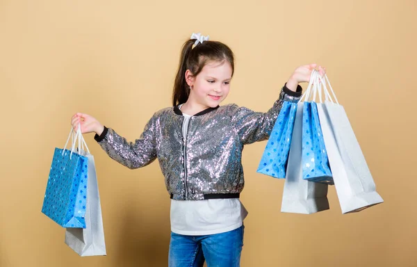 Kiskereskedelem. Üdülési megtakarítás. Vidám gyerek. Egy kislány ajándékkal. Értékesítési kedvezmények. Divat és stílus. ügyfél falkával. Egy kislány bevásárlószatyorral. Határozottan muszáj. Biztos. Ez kötelező. — Stock Fotó