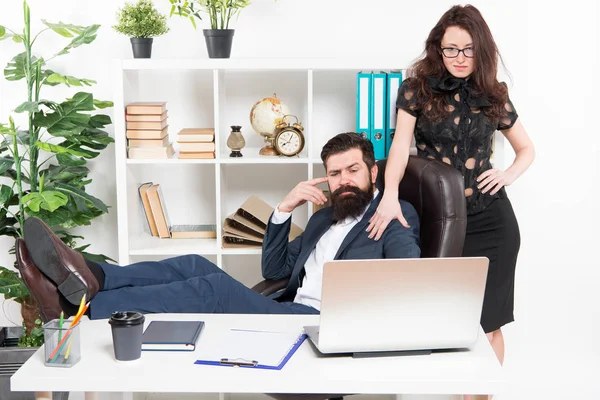 Business people and office staff. Sexy secretary personal assistant. Typical office life. Man bearded hipster boss sit in leather armchair office interior. Boss and secretary girl at workplace