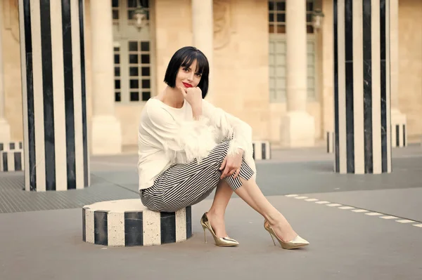 Concepto de moda urbana. Chica de moda dama con peinado bob al aire libre de la arquitectura urbana de fondo. Mujer modelo de moda posando al aire libre. Chica morena bob peinado se ve elegante — Foto de Stock