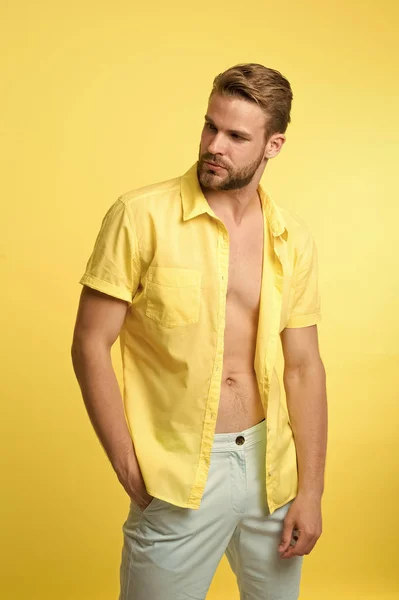 Чоловік спокійно позує впевнено жовтий фон. Хлопець носить сорочку без ґудзиків з гладкою шкірою на грудях. Процедура видалення волосся. Зняти одяг і не соромитися. Чоловіча депіляція волосся груди — стокове фото