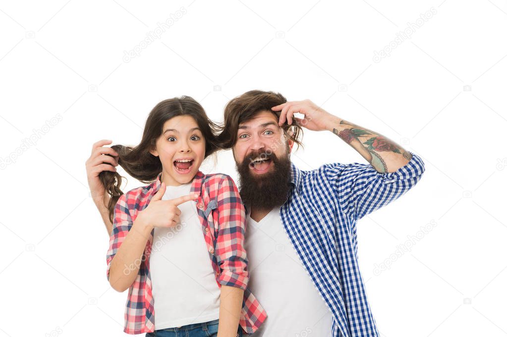 He envies my hairstyle. Man with beard and little girl long hair on white background. Father play with hair of kid. Hairdresser and barber concept. Having fun with long hairstyle. Hair care