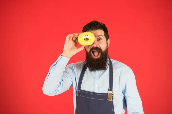 Je bent wat je eet. Baker Hold donut. Grappige hipster. Bearded Man Cook. Chef-kok man in café. Dieet en gezonde voeding. Bearded man eet donut. Calorie. Honger voelen. Bearded chef-kok. Bearded Man in schort — Stockfoto