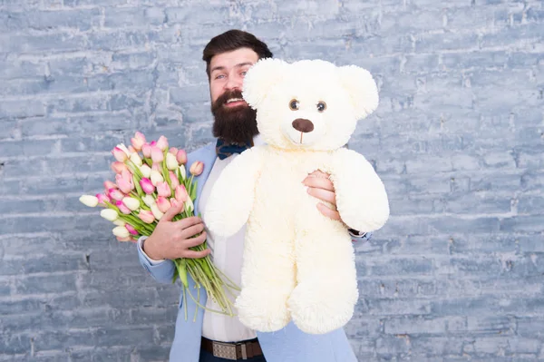 Bear toy. Enjoying spring holiday. Bearded man with tulip bouquet and bear. Spring gift. Bearded man with flowers. Cute bear. March 8. Love date. international holiday. Womens day. Big bear gift — Stock Photo, Image
