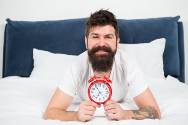 Neden her sabah erken kalkmalısın? Erken yükselen sağlık yararları. Erken uyanma hazırlamak ve zamanında olmak için daha fazla zaman verir. Hipster sakallı adam çalar saatle yatakta yatıyordu. Uyanma zamanı