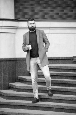 Hippi elinde kağıt kahve fincanı tutuyor ve şehir ortamının tadını çıkarıyor. Giderken iç. Sakallı hippi adam kahveyi tercih ediyor. İş adamı dışarıda kahve içer. Enerjiyi yeniden yüklüyorum. Kahve molası.