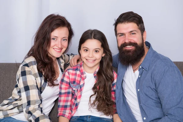 Typical family with single child. Family spend weekend together. Friendly family sit couch posing for photo family album. Mom dad and daughter smiling relaxing on couch. Family bonds concept