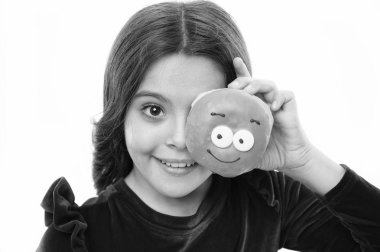 Kız tatlı çörek elinde beyaz camlı arka plan tutun. Çocuk gülümseyen kız çörek ısırmaya hazır. Şeker dükkanı ve ekmek kavramı. Pişmiş Donuts büyük fanlar çocuklar. Taze çörek sipariş etmek için yapılan karşı koyabilir