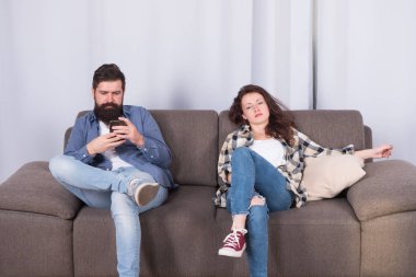 Mobil gadget bağımlılığı. Adam sakallı hipster yakın rahatlatıcı kız arkadaşı ise akıllı telefon oynamak. İnternet sörfü ve sosyal ağlar. Mobil internet bağımlılığı. Koca bağımlısı internet online oyunlar