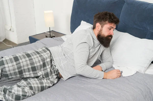 Difícil de despertar. El hombre barbudo hipster quiere dormir por la mañana. hombre somnoliento brutal en el dormitorio. macho maduro con barba en pijama en la cama. dormido y despierto. energía y cansancio. Despierta no hoy. — Foto de Stock