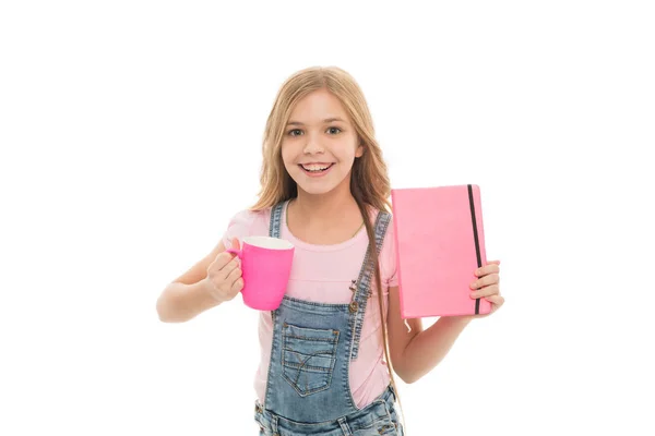 Lanza tu día con el desayuno. Linda chica sosteniendo la taza y el cuaderno. Una niña disfrutando de su desayuno escolar. Bebé bebiendo té o leche para el desayuno. Niño feliz desayunando por la mañana — Foto de Stock