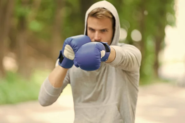 Esportista concentrado luvas de treino de boxe. Atleta concentrado rosto esporte luvas prática habilidades de luta natureza fundo. Atacar ou defender esteja sempre pronto. Boxer focado no boxe — Fotografia de Stock