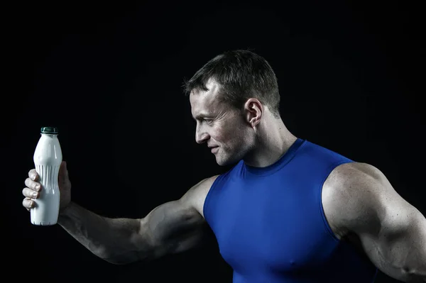 Knappe bodybuilder man met gespierd lichaam houdt drank fles — Stockfoto