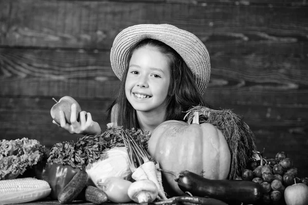 Traditional autumnal fest. Farm activities for kids. Girl kid farm market with fall harvest. Child celebrate harvesting. Kid farmer with harvest wooden background. Family farm festival concept