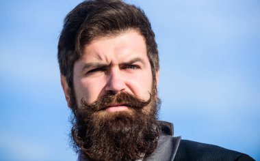 Şık bir görünüme yatırım yapın. Kalın sakalı hızlı uzat. Adam sakallı hipster resmi takım mavi gökyüzü arka plan giymek. Sakal ve bıyık bakımı. Sakal moda trendi. Her sakal tamamen eşsiz