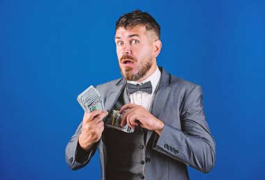 Nakit işlem iş. Kolay nakit krediler. Resmi takım elbise mavi arka plan doları banknot yığını tutun. İşadamı nakit para var. Zenginlik ve refah kavramı. Kolay ve hızlı bir şekilde nakit alın