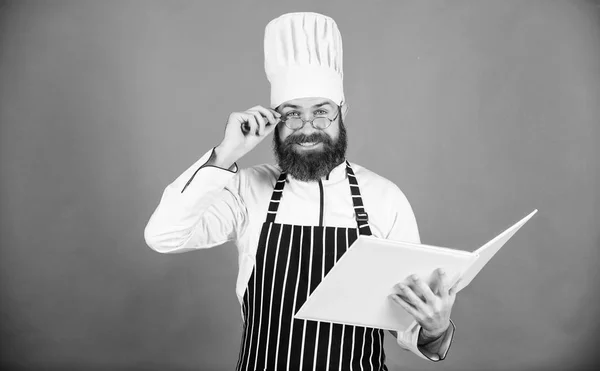 Man leren recept. Probeer iets nieuws. Koken op mijn hoofd. Koken vaardigheden te verbeteren. Boek recepten. Volgens recept. Man met baard chef-kok koken voedsel. Culinaire kunsten concept. Amateur kok Lees boek recepten — Stockfoto