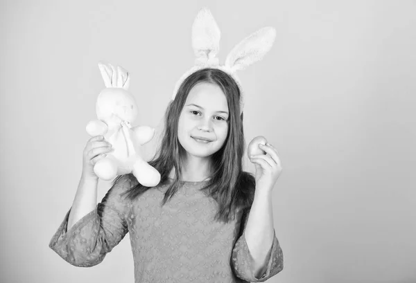 Påsk-symboler och traditioner. Lekfulla barn med mjuk leksak. Möt våren semester. Påsk ägg jagar som en del av festivalen. Flicka lilla barnet easter bunny tillbehör håll färgade ägg. Beskärningen av påskharen — Stockfoto