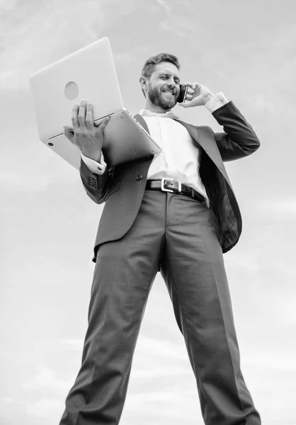 Парень формально костюм современных технологий менеджер предприниматель ответить на телефонный звонок. Человек ухоженный бизнесмен держит ноутбук в то время как говорят телефон синий фон неба. Всегда на связи. Коммуникационные навыки — стоковое фото