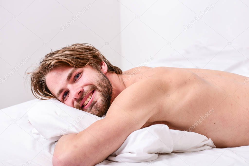 Man handsome guy lay in bed in morning. Tips on how to wake up feeling fresh and energetic. How to get up in morning feeling fresh. Enjoy every morning. Morning routine tips to feel good all day