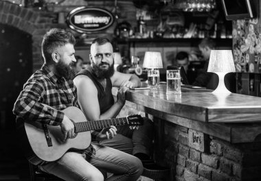 Neşeli arkadaşları gitar müzik ile rahatlayın. Cuma gevşeme çubuk. Arkadaşlar rahatlatıcı bar veya pub. Gerçek erkekler eğlence. Hipster acımasız sakallı arkadaş ile boş zaman harcamak çubuk. Man oyun gitar çubuk