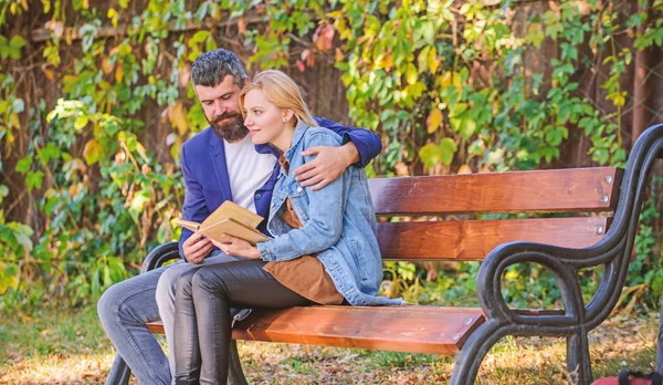 Meeting people with similar interests. Man and woman sit bench park. Read same book together. Couple interested literature. Literature common interest. How to find girlfriend with common interest — Stock Photo, Image