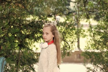 Yaz parkta uzun sarı saçlı çocuk. Küçük kız oyun temiz hava açık. Doğa kulaklıktan olan moda çocuk. Tatil yaz ve rahatla. Müzik ve modern teknoloji