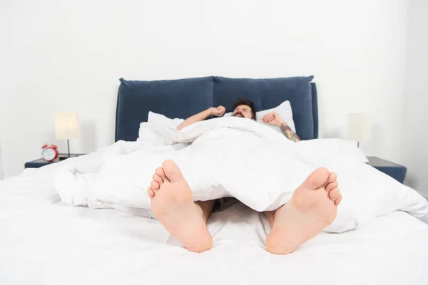 Relajante en el dormitorio. Dulces sueños. dormido y despierto. varón en la cama. El hombre duerme por la mañana. energía y cansancio. un hombre somnoliento en el dormitorio. Un hombre soñando despierto. Día durmiendo. Buena siesta. Tiempo para descansar —  Fotos de Stock