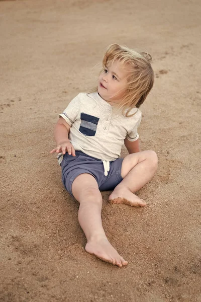 Primeras vacaciones con consejos y consejos para niños. El niño se sienta en la arena. Los niños pequeños disfrutan de vacaciones en la playa. Cuida a los niños de viaje de seguridad. Las mejores actividades para niños pequeños en la playa. Unidos con la naturaleza —  Fotos de Stock