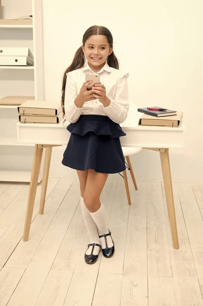 Always in touch. Kid girl send message to parents. Schoolgirl awkward smiling face has bad news. Girl nervous informing parents about bad marks in school. Awkward about fail or mistake