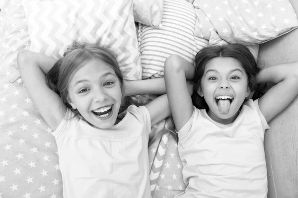 Divirtiéndose con el mejor amigo. Los niños alegre humor juguetón divertirse juntos. Fiesta de pijama y amistad. Hermanas felices niños pequeños relajarse en el dormitorio. Amistad de niñas pequeñas. Ocio y diversión — Foto de Stock