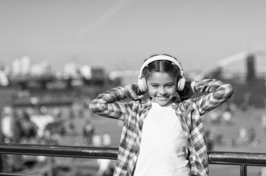 Her yerde müziğin tadını çıkar. Dinlemeyi hak eden en iyi müzik uygulamaları. Kız çocuk açık havada modern kulaklıklarla müzik dinler. Bedavaya dinle. Müzik ailesi aboneliğini al. Milyonlarca şarkıya erişim