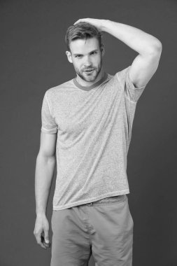 Erkeklik kavramı. Kaslı kollu, kendinden emin ve güçlü bir adam. Kaslı bir vücuda sahip olmak kendine daha çok güvenmeni sağlar mı? Güçlü ve kaslı. Menekşe arka plandaki yakışıklı, tıraşsız adam.