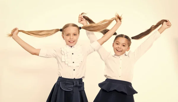 As meninas mostram caudas compridas. Crianças da escola. Crianças felizes gostam de cabelo saudável. Cabeleireiro é a nossa paixão — Fotografia de Stock