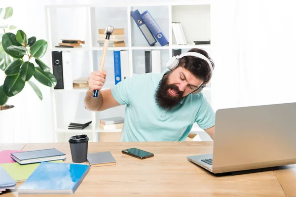 Llamando un cliente molesto. Hombre barbudo chico auriculares oficina swing martillo en el teléfono inteligente. Comunicación estropeada. Negociaciones móviles fallidas. Lo más molesto del trabajo en el centro de llamadas. Llamada entrante — Foto de Stock