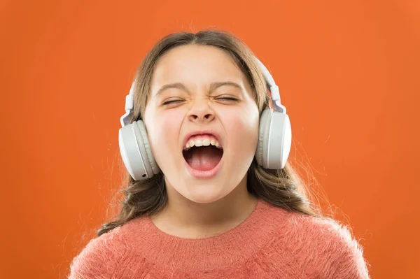 Para melhores performances vocais. Criança pequena adorável fazendo vocal na música. Menina ouvindo música e cantando melodia vocal. Cantora talentosa ou vocalista treinando seu vocal em fones de ouvido sem fio — Fotografia de Stock