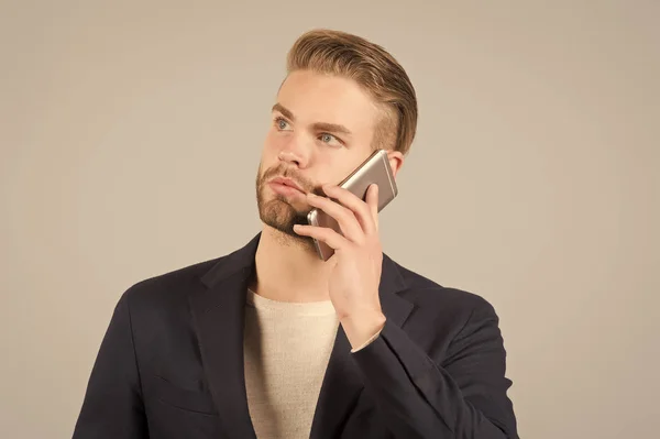 Espera conexión. Hombre bien arreglado hablar de fondo gris teléfono móvil. El hombre de negocios llama seriamente al teléfono móvil. Conexión de llamada móvil. Chico guapo oficinista atractivo hablar teléfono móvil — Foto de Stock