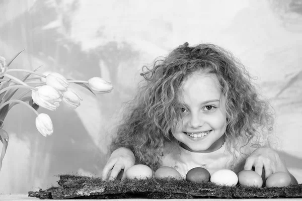 带着彩蛋和郁金香花的快乐的东方女孩 — 图库照片