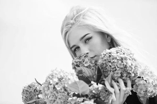 Lente de bloei. Inschrijving blond meisje houdt hydrangea bloemen boeket. Begrip van de natuurlijke schoonheid. Huid verzorging en schoonheidsbehandelingen. Zachte bloem voor gevoelige vrouw. Pure schoonheid. Tederheid van jonge huid — Stockfoto