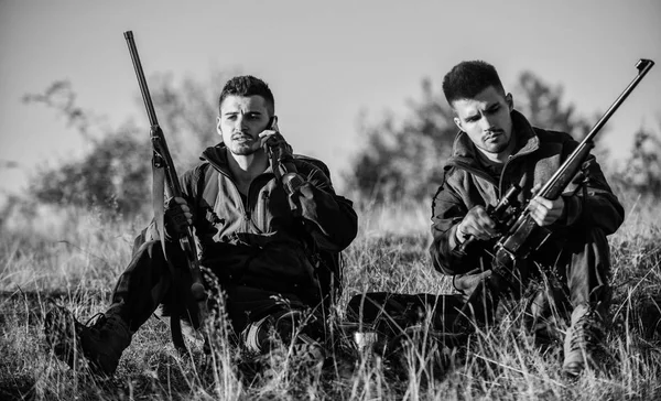 Hunters friends enjoy leisure. Rest for real men concept. Hunters with rifles relaxing in nature environment. Hunting with friends hobby leisure. Hunters satisfied with catch drink warming beverage — Stockfoto