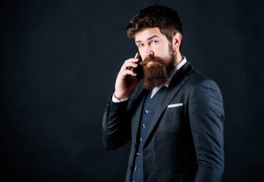 Teknoloji her zaman iş yerinde ona yardımcı olur. Sakallı olgun hipster telefonda konuşuyor. bıyıklı vahşi kafkas hipster. takım elbiseli iş adamı. çevrimiçi ve çevik. Akıllı telefon ile sakallı adam