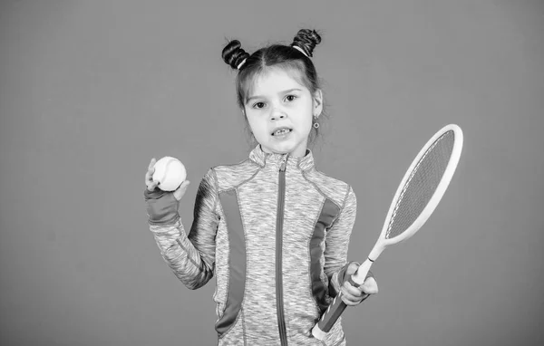 Educazione sportiva. Piccolo cutie piace il tennis. Piccolo bambino costume sportivo giocare a tennis gioco. Insegnami a giocare a tennis. Ragazza carina bambino doppio panino acconciatura tennista. Infanzia e giochi attivi — Foto Stock