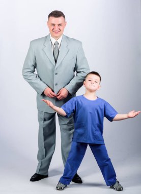 Baba patron. Baba ve sevimli küçük oğul. Çocuk bakımı gelişimi yetiştirme. Saygın bir meslek. Aile işi. Saygıdeğer bir iş adamı ve küçük çocuk doktor üniforması. Doktor saygın kariyer