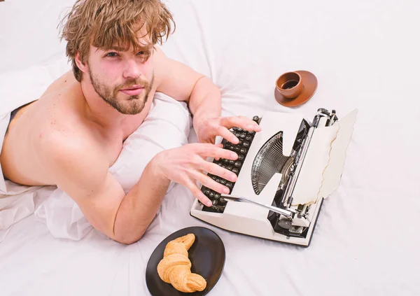 Man writer lay bed bedclothes working book. Writer tired desperate author used old fashioned typewriter. Author drink coffee have breakfast in bed. Lack of inspiration or idea. Creativity crisis