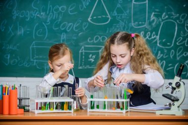 Kimya dersinde. Küçük okul çocukları derste test tüpleri tutuyorlar. Küçük kız öğrenciler okulda ders öğreniyorlar. Fen dersinde okul dersi olması