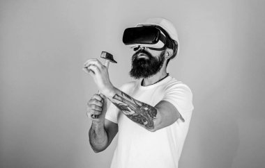 Oluşturucu ve yenileme kavramı. Vr bardaklarda sakallı çekiç, açık mavi renkli tutar. Adam Hmd Vr yüzey içine sanal çivi çekiç ile. Hipster yenileme sanal gerçeklik ile meşgul