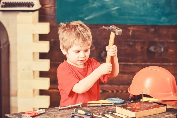 Νήπιο στο πολυάσχολο πρόσωπο παίζει με σφυρί εργαλείο στο σπίτι σε εργαστήριο. Παιδί, χαριτωμένη και αξιαγάπητη παίζοντας ως οικοδόμος ή επισκευαστή, την επισκευή ή την handcrafting. Παιδί boy Παίξτε ως handyman. Handcrafting έννοια — Φωτογραφία Αρχείου