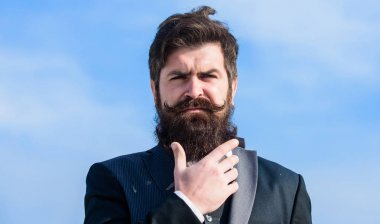 Sakallı adam. Gelecekteki başarı. Erkek resmi moda. bıyıklı vahşi kafkas hipster. İş adamı gökyüzüne karşı. Sakallı olgun hipster. Sakallı adam sakala dokunur. Sakallı adam dışarıda