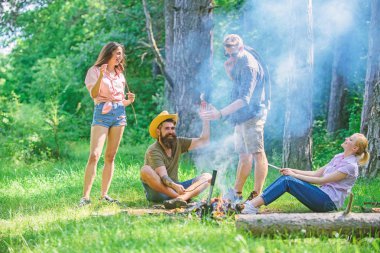 Yaz piknik katılın. Şirket sosis sopa üzerinde kavurma eğleniyor. Büyük piknik için toplama. Şenlik ateşi takılmak ve hazırlamak için toplantı arkadaşlar sosis aperatifler doğa arka plan kavrulmuş