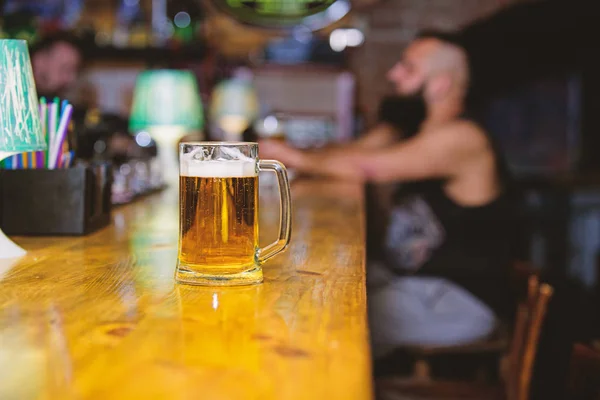 Beer mug on bar counter defocused background. Glass with fresh lager draft beer with foam. Mug filled with cold tasty beer in bar. Friday leisure tradition. Beer pub concept. Weekend lifestyle